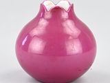 purple vase with a bow on the top of it sitting on a white surface