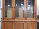 une photo d'un vaisselier en bois avec des portes vitrées dans une pièce