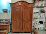 a wooden armoire in the corner of a room