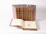 several old books stacked on top of each other on a white surface