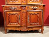 a wooden cabinet that has a mirror on top of it