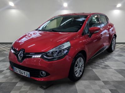 une voiture rouge est garée dans une grande pièce au sol en damier