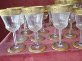 many wine glasses sitting on a table with gold rims