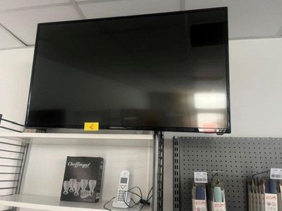 une télévision à écran plat accrochée au mur au-dessus d'une étagère