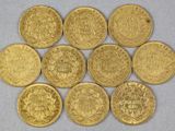 un tas de pièces d'or posé sur une surface blanche