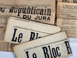 several old french newspapers sitting on top of each other on a table
