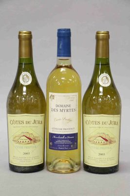 trois bouteilles de vin blanc posées les unes à côté des autres sur une table
