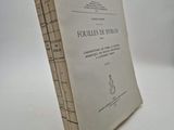 an old book sitting on top of a white table next to a white wall