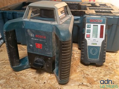 two bosch tools sitting on top of a wooden table next to a tool box