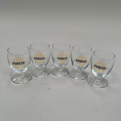 quatre verres vides posés sur une table devant un fond blanc