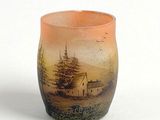 un petit vase avec une peinture sur une surface blanche