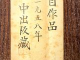 chinese writing on a piece of paper on a wooden table