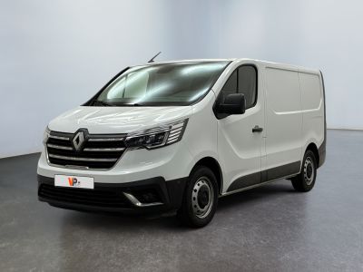 La camionnette blanche est garée dans une grande pièce.