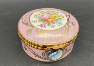 une boîte rose et dorée sur laquelle est représenté un oiseau