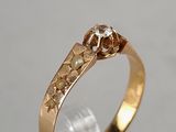 a close up of a gold ring with a diamond on it