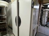 two refrigerators that are sitting in a room