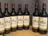 six bouteilles de vin sont alignées sur un tonneau en bois