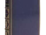 un vieux livre à la couverture bleue, rehaussée de dorures sur fond blanc