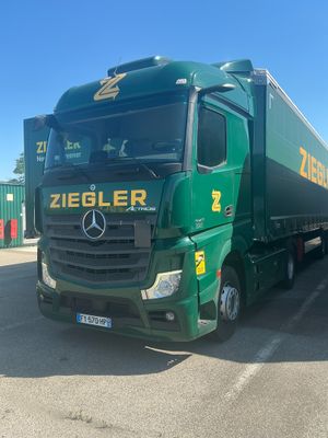 a green truck that is parked in a parking lot