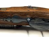 a close up of a rifle on a white surface
