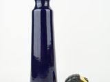 a blue vase next to a measuring tape on a white surface