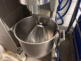 a mixer with a whisk inside of it in a kitchen