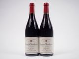 deux bouteilles de vin rouge posées l'une à côté de l'autre sur une surface blanche