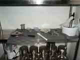 many pots and pans on the shelf in the kitchen