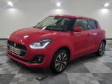 une Suzuki Swift rouge garée dans une pièce au sol à carreaux