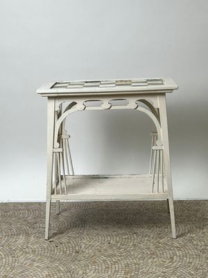 une petite table blanche avec un plateau en verre, posée sur un sol recouvert de moquette