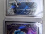 three different pokemon cards in plastic cases on a white surface