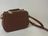 the small brown purse is sitting on a white surface