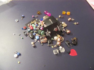 un tas de bijoux posés sur une table, avec un cœur rouge