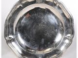 un plateau d'argent antique sur un support sur une surface blanche