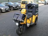 une moto jaune avec un sac noir à l'arrière