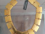 gold plated necklace on display in glass case with tag