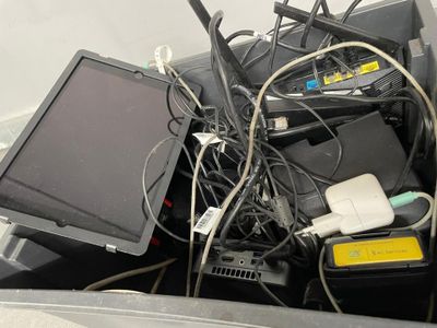 a lot of wires and electronics in a bin