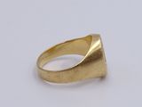 a close up of a gold ring on a white surface