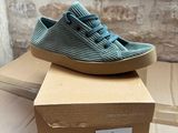 nike tennis shoes in a box on a table next to a brick wall