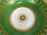 a green and gold plate with a yin symbol on it