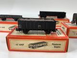 several toy train cars sitting on top of boxes on a white surface