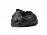 the large black bag is sitting on a white surface