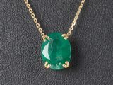Gros plan sur un collier orné d'une pierre verte