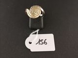 gros plan d'une bague sur une surface noire avec une étiquette de prix
