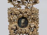 un cadre doré richement décoré, dans lequel figure le portrait d'une femme entourée de fleurs et de feuilles