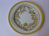 a yellow and white plate with a design on it