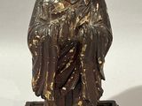statue en bronze représentant une personne assise sur un socle, sur fond blanc