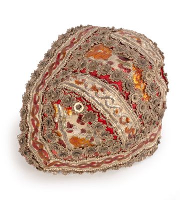 embroidered and beaded hat on white background with red, orange, and yellow accents
