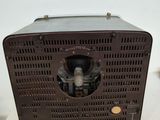 an old radio sitting on top of a white table next to a white wall