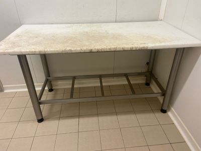 un plan de travail en marbre dans une salle de bains au sol carrelé